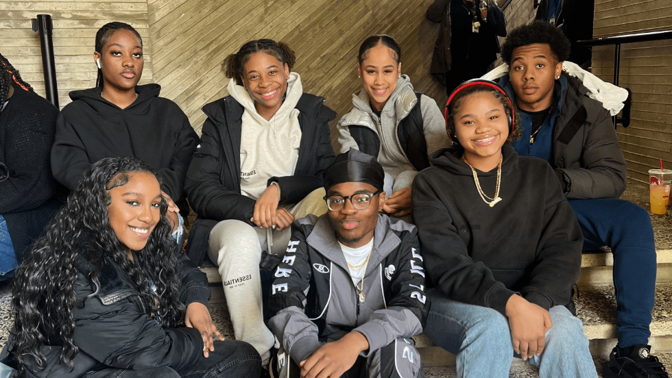 A group of UMass Early College students sitting on the steps at UMass Lowell
